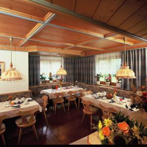 萨尔巴赫玛丽亚滑雪和自行车膳食公寓的餐厅设有桌椅,并种有鲜花