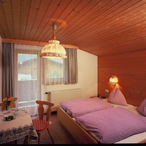 萨尔巴赫玛丽亚滑雪和自行车膳食公寓的一间卧室配有一张床和一个吊灯