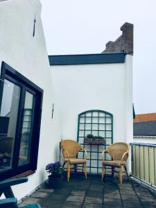 滨海卡特韦克Kamers van Goud的两把椅子位于带窗户的庭院