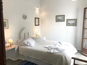 纳乌萨斯沃罗欧斯洋房酒店的卧室配有白色的床和带两盏灯的书桌。