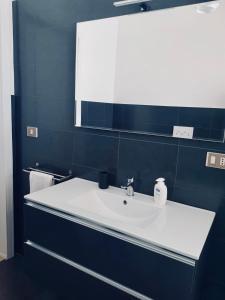 马蒂诺Appartamento Via del Mare的浴室设有白色水槽和镜子