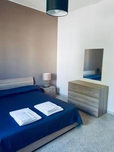 马蒂诺Appartamento Via del Mare的一间卧室配有一张带蓝色床单和镜子的床