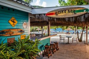WillikiesThe Verandah Antigua - All Inclusive - Adults Only的海滩边的酒吧,带冲浪板