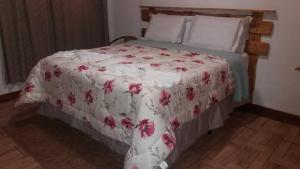圣安东尼奥-杜皮尼亚尔品哈伦斯旅馆的一张床上的白色毯子,上面有红色的鲜花