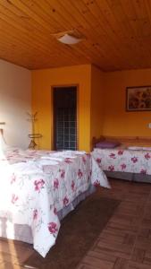 圣安东尼奥-杜皮尼亚尔品哈伦斯旅馆的一间卧室配有两张带白色床单和鲜花的床。