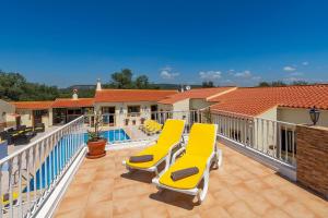 圣巴托洛梅乌迪梅西尼什Casa dos Ninos的阳台设有黄色椅子和游泳池