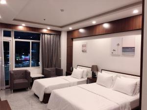 Long KhanhQuốc Thanh Hotel的酒店客房设有两张床和窗户。