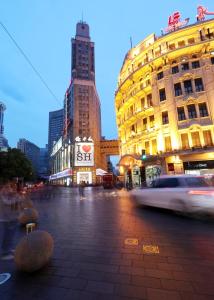 上海上海七重天宾馆的一条城市街道,街道上有许多建筑,一辆汽车经过