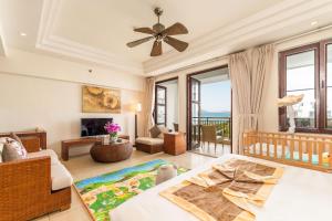 三亚三亚亚龙湾爱琴海套房度假酒店（开放式简易厨房）的客厅配有床和沙发