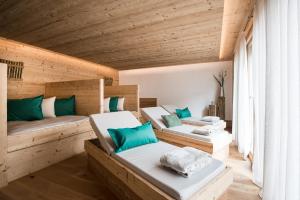 圣马蒂诺-因巴迪亚Les Dolomites Mountain Lodges的木墙客房的两张床