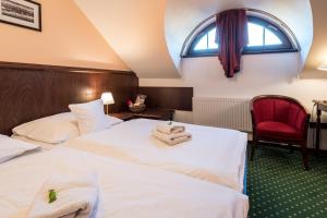乌赫尔堡赫吉玛纳萨洛维奇酒店的酒店客房,设有两张床和一张红色椅子