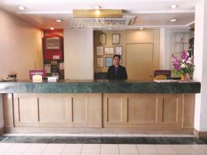 拿笃The Executive Hotel Lahad Datu的站在餐厅柜台的女人