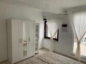 查德尔帕罗奥Apartment Luna Nudist Place的卧室配有白色橱柜和窗户。