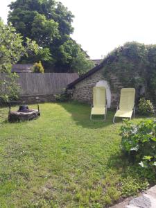 蒂豪尼Babamúzeum kis apartman的两把椅子坐在院子里的草地上