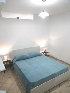 莱乌卡Casa vacanza Leuca的一间卧室配有蓝色的床和2个床头柜