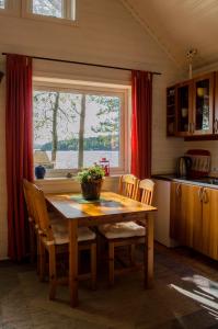 TämtaStrandstuga的厨房配有木桌、椅子和窗户。