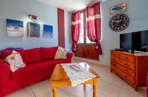 阿罗纳La Niña - Ocean View Apartment的客厅配有红色的沙发和桌子