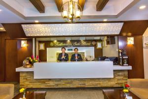 加德满都Kathmandu Suite Home的两个男人站在餐厅柜台后面