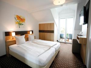 沃尔特湖畔佩莎赫戴安娜酒店 的酒店客房设有一张大床和一台电视。