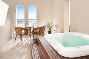 里米尼国宾大酒店的带浴缸的客房内配有桌椅