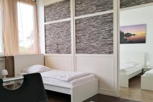 朗根费尔德Work & stay Langenfeld的一间卧室设有一张床和砖墙