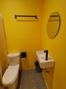 奥斯洛布Way Shack Hostel的黄色的浴室设有卫生间和水槽