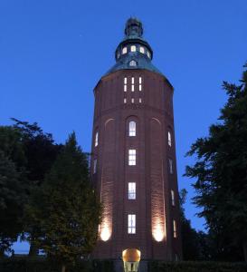 斯塔德Ystads Gamla Vattentorn的一座高大的塔楼,晚上有灯