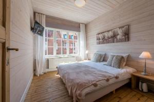 尼乌波特Maison Mariette的铺有木地板的客房设有一间带大床的卧室