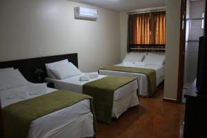 戈亚尼亚品赫罗斯酒店的酒店客房设有两张床和窗户。