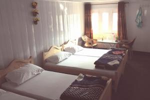 ShardiSharda Highland Hotel的一间卧室设有两张床、一张桌子和一个窗口。