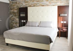 VerdelloQuattro Gatti Rooms&Suite的一间卧室配有一张大床和大床头板