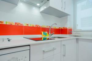 罗塔Apartamento Sea Views Rota的厨房配有红色和白色的橱柜和水槽