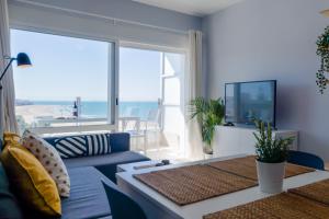 罗塔Apartamento Sea Views Rota的客厅设有蓝色的沙发和大窗户