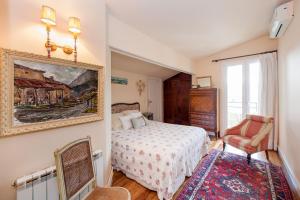 奥利奥卡萨如若麦兰乡村民宿的卧室配有一张床,墙上挂有绘画作品