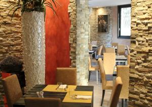 VerdelloQuattro Gatti Rooms&Suite的一间带桌椅的餐厅以及砖墙