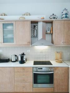 普拉提伊亚洛斯西弗诺斯Flora's Guesthouse的厨房配有木制橱柜和炉灶烤箱。