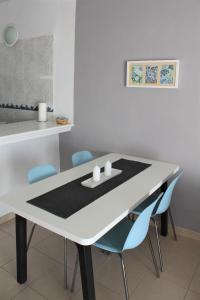 卡亚俄萨尔瓦赫卡亚俄萨尔瓦赫2号公寓的白色的餐桌和蓝色的椅子
