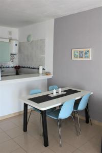 卡亚俄萨尔瓦赫卡亚俄萨尔瓦赫2号公寓的一间带桌子和蓝色椅子的用餐室