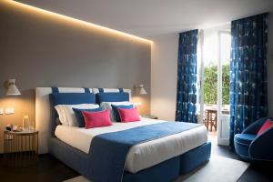 马尔米堡拜伦酒店的一间卧室配有一张带蓝色和红色枕头的大床