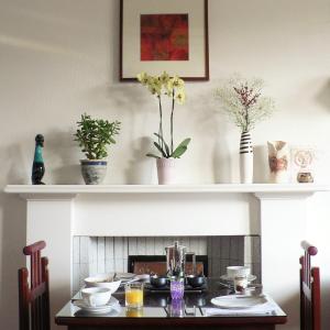爱丁堡Straven Guesthouse的一间带桌子和壁炉的用餐室