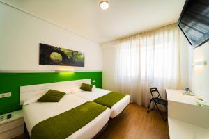 维多利亚-加斯特伊兹Hotel Centro Vitoria AutoCheckIn的一间卧室设有一张大床和绿色的墙壁