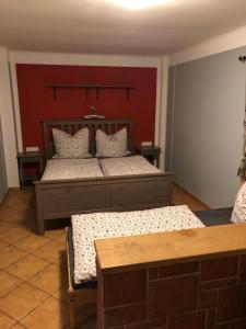 PetrovicePenzion RETRO的一间卧室设有两张床和红色的墙壁