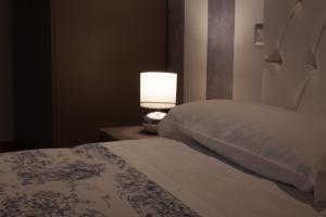 维罗纳穆赛奥公寓的一间卧室配有一张床和一张桌子上的台灯