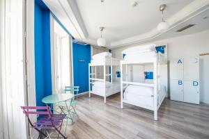 马德里Safestay Madrid Central的客房设有两张双层床和一张桌子及椅子。