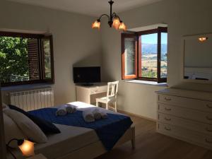 San Donato di NineaGreen Deluxe Apartment “La locanda del Borgo”的一间卧室配有一张床、梳妆台和窗户。