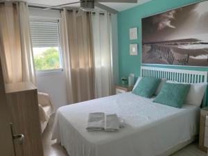 卡沃内拉斯Apartamento Nautilus Playa的一间卧室配有一张床,上面有两条毛巾