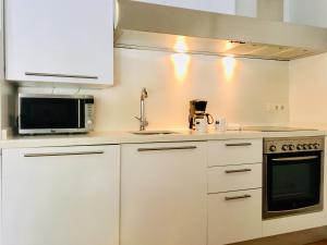 阿利坎特Apartamentos Santa Faz by Be Alicante的白色的厨房配有水槽和微波炉