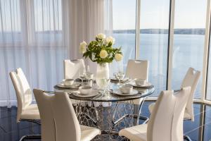 斯旺西Just Stay Wales - Meridian Quay Penthouses的一张餐桌,配有白色的椅子和花瓶