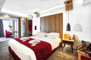 海若克利欧卡普西斯道夫伊拉克利翁酒店的一间卧室配有一张大床和两条毛巾