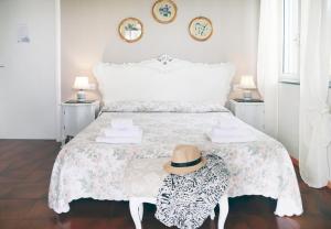 阿奇卡斯泰洛奥坦西亚别墅住宿加早餐旅馆的一间白色的卧室,配有一张带帽子的床